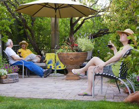 People relaxing under an umbrella in a garden patio
